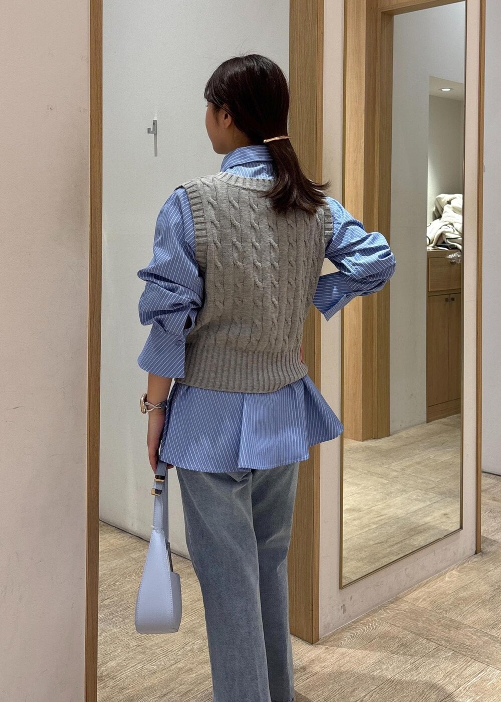 ブルー系のシャツ/ブラウス、グレー系のベスト、ブルー系のデニムパンツを着用したレディースの冬コーディネートの8枚目の写真