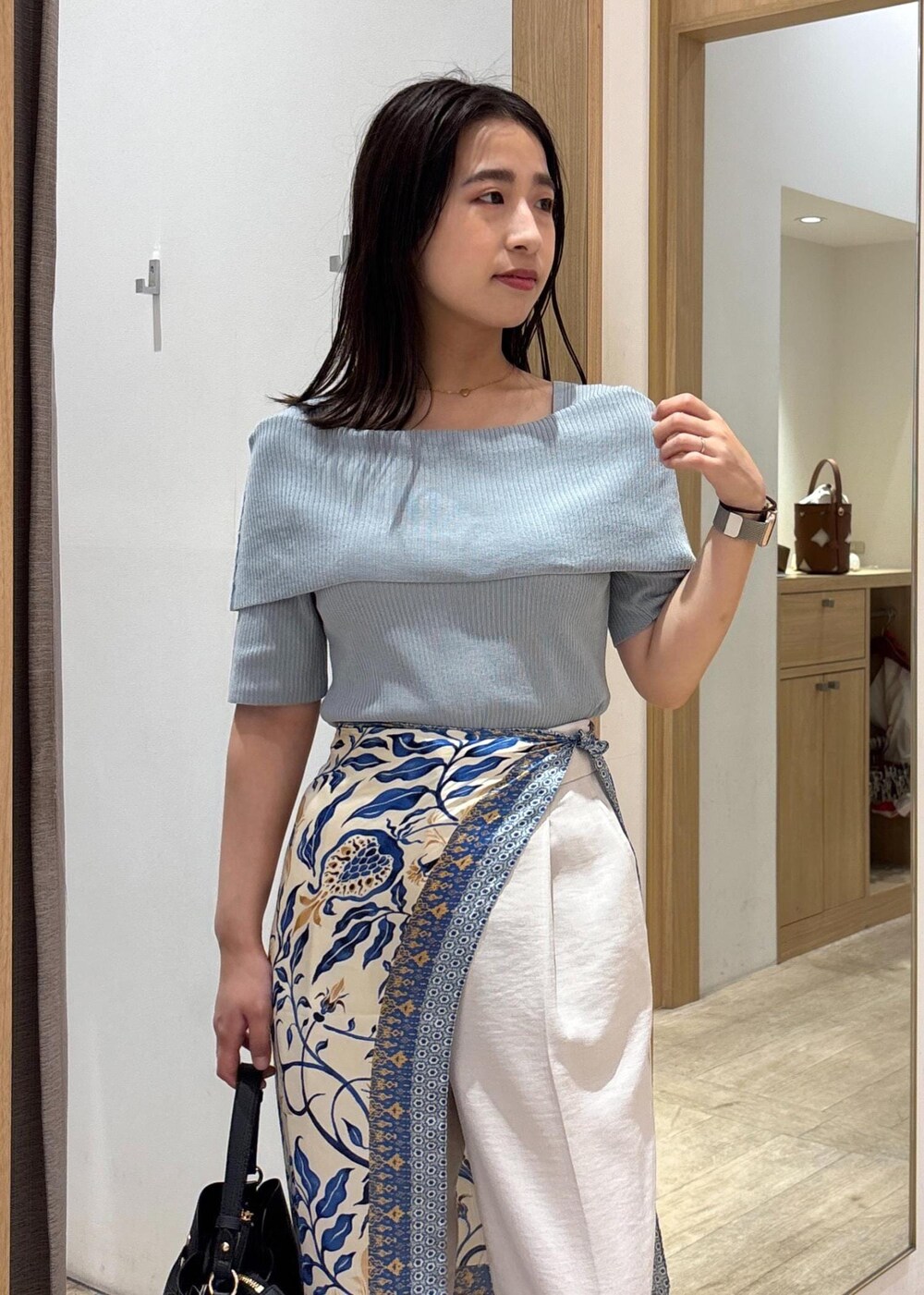 ブラウン系のパンプス、グリーン系のニット/セーター、ホワイト系のスラックスを着用したレディースの夏コーディネートの6枚目の写真