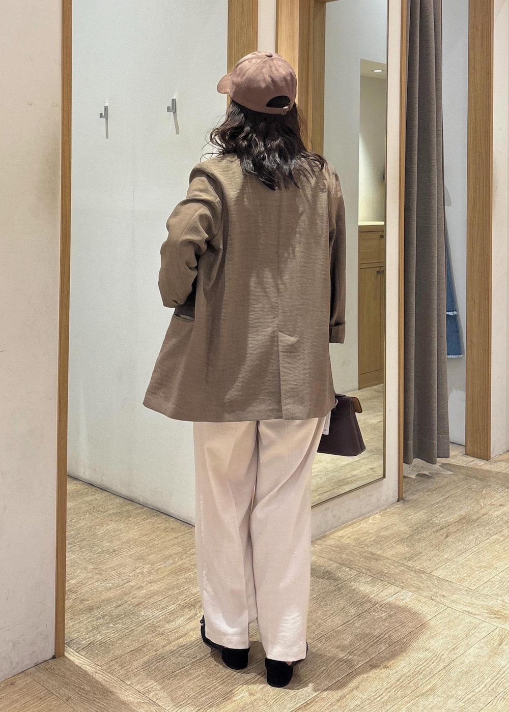 ブラウン系のショルダーバッグ、グリーン系のテーラードジャケット、ホワイト系のスラックスを着用したレディースの夏コーディネートの3枚目の写真