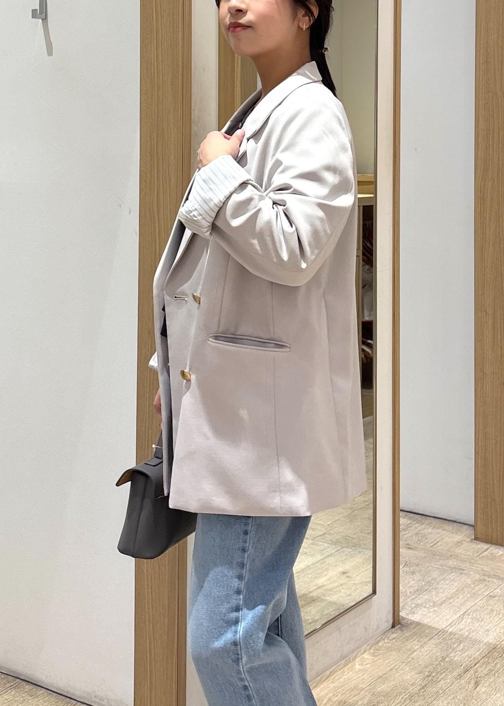 グレー系のショルダーバッグ、ベージュ系のテーラードジャケット、ブルー系のデニムパンツを着用したレディースの春コーディネートの8枚目の写真