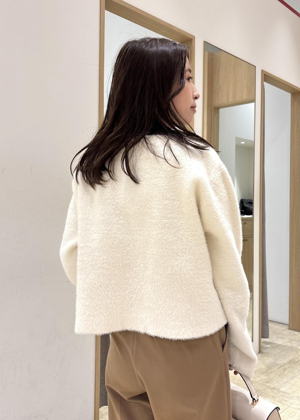 ホワイト系のカーディガン/ボレロ、ブラック系のTシャツ/カットソー、ブラック系のブーツを着用したレディースの秋コーディネートの8枚目の写真