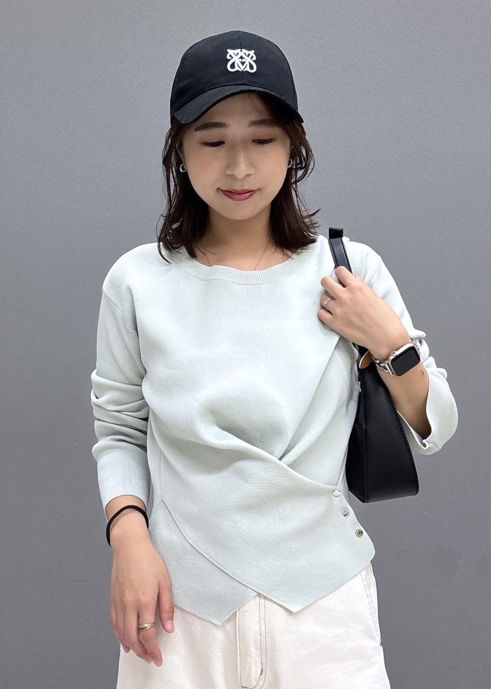 ブラック系のショルダーバッグ、シルバー系のパンプス、グリーン系のニット/セーターを着用したレディースの秋コーディネートの5枚目の写真