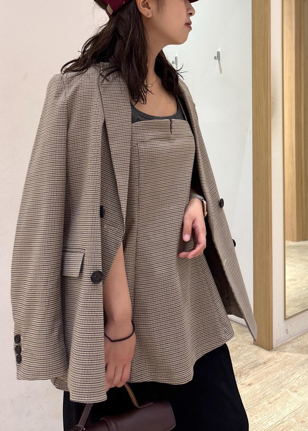 ブラウン系のショルダーバッグ、ベージュ系のテーラードジャケット、ベージュ系のキャミソールを着用したレディースの秋コーディネートの8枚目の写真