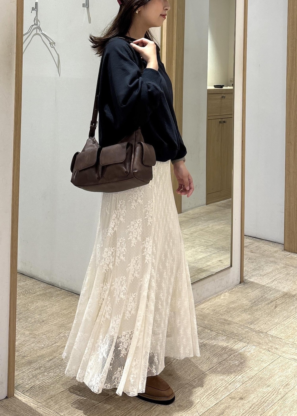 ブラウン系のショルダーバッグ、ベージュ系のローファー、ホワイト系のスカートを着用したレディースの秋コーディネートの5枚目の写真