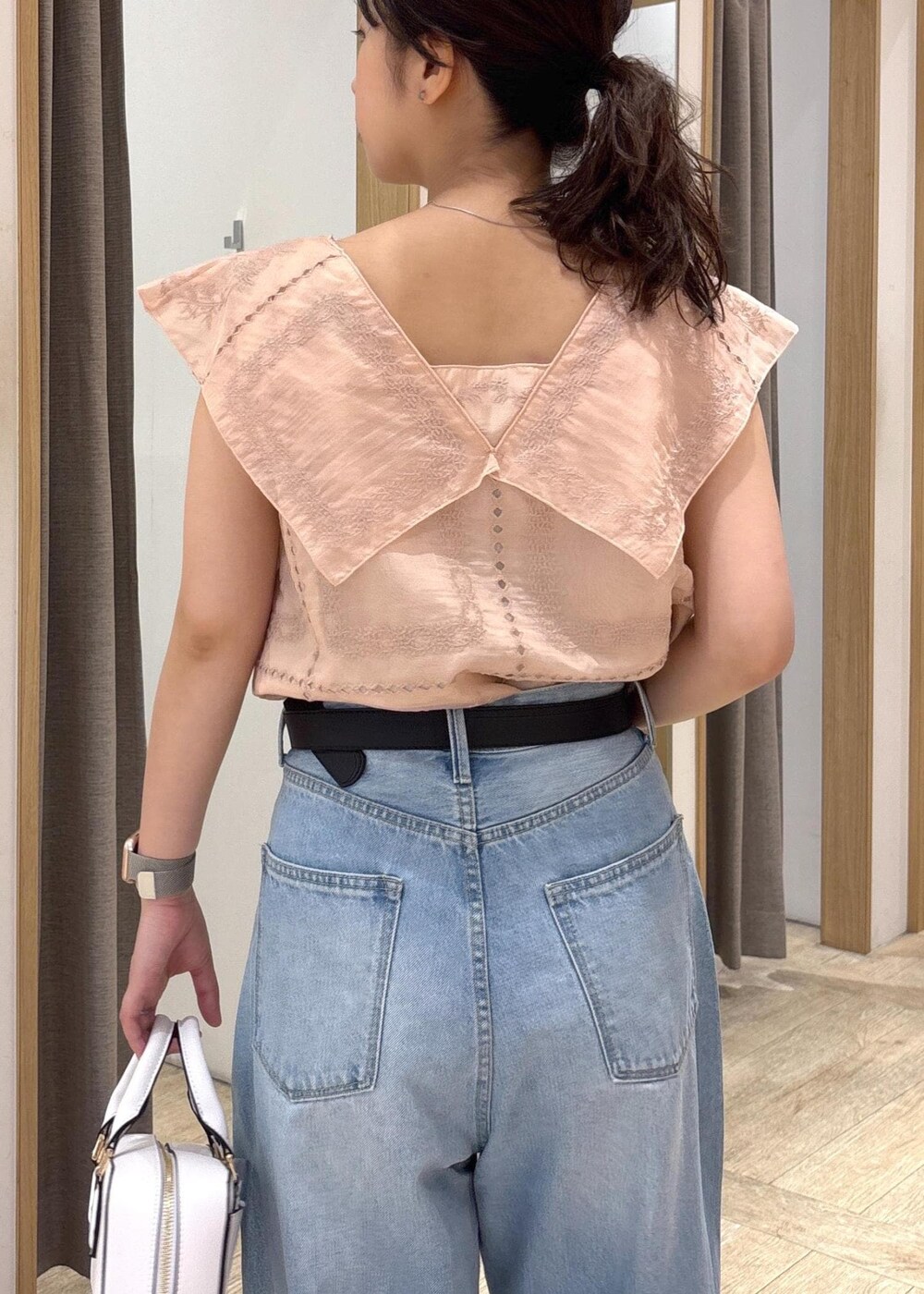 ブルー系のデニムパンツ、ブラック系のサンダル、ブラック系のショルダーバッグを着用したレディースの夏コーディネートの6枚目の写真