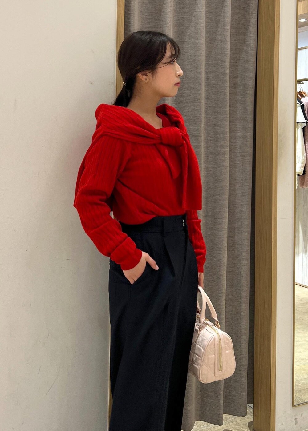 シルバー系のパンプス、レッド系のカーディガン/ボレロ、レッド系のニット/セーターを着用したレディースの冬コーディネートの6枚目の写真