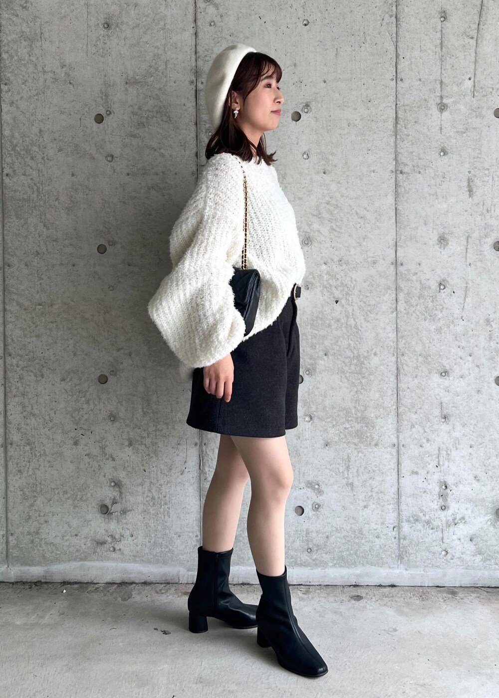 ブラック系のブーツ、ホワイト系のニット/セーター、グレー系のその他パンツを着用したレディースの秋コーディネートの5枚目の写真