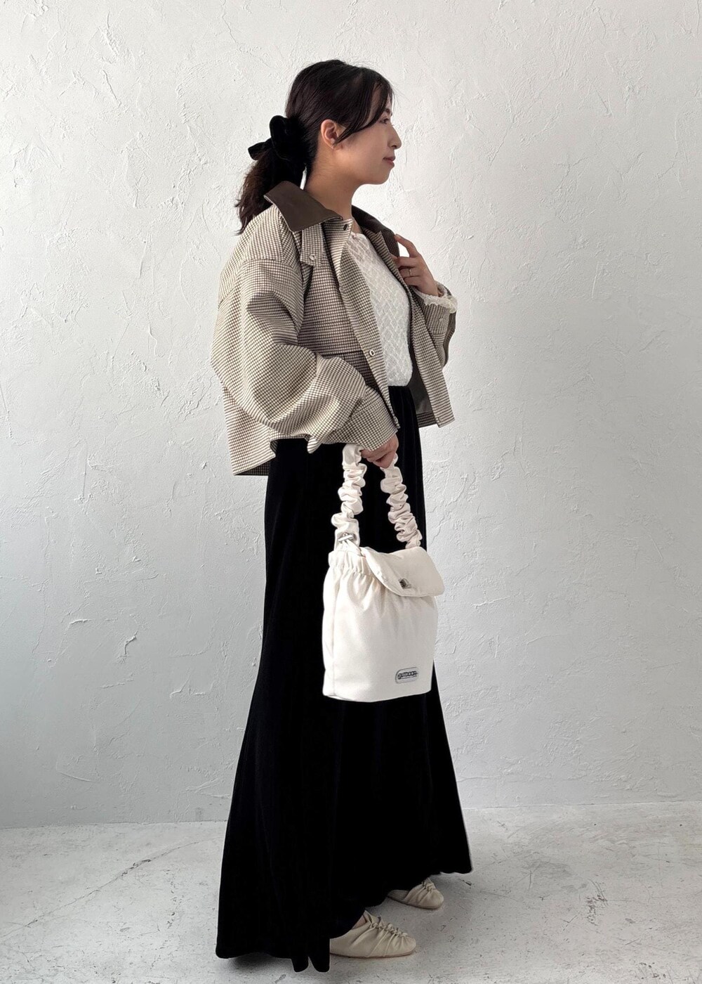 ホワイト系のショルダーバッグ、ホワイト系のTシャツ/カットソー、ホワイト系のパンプスを着用したレディースの夏コーディネートの2枚目の写真