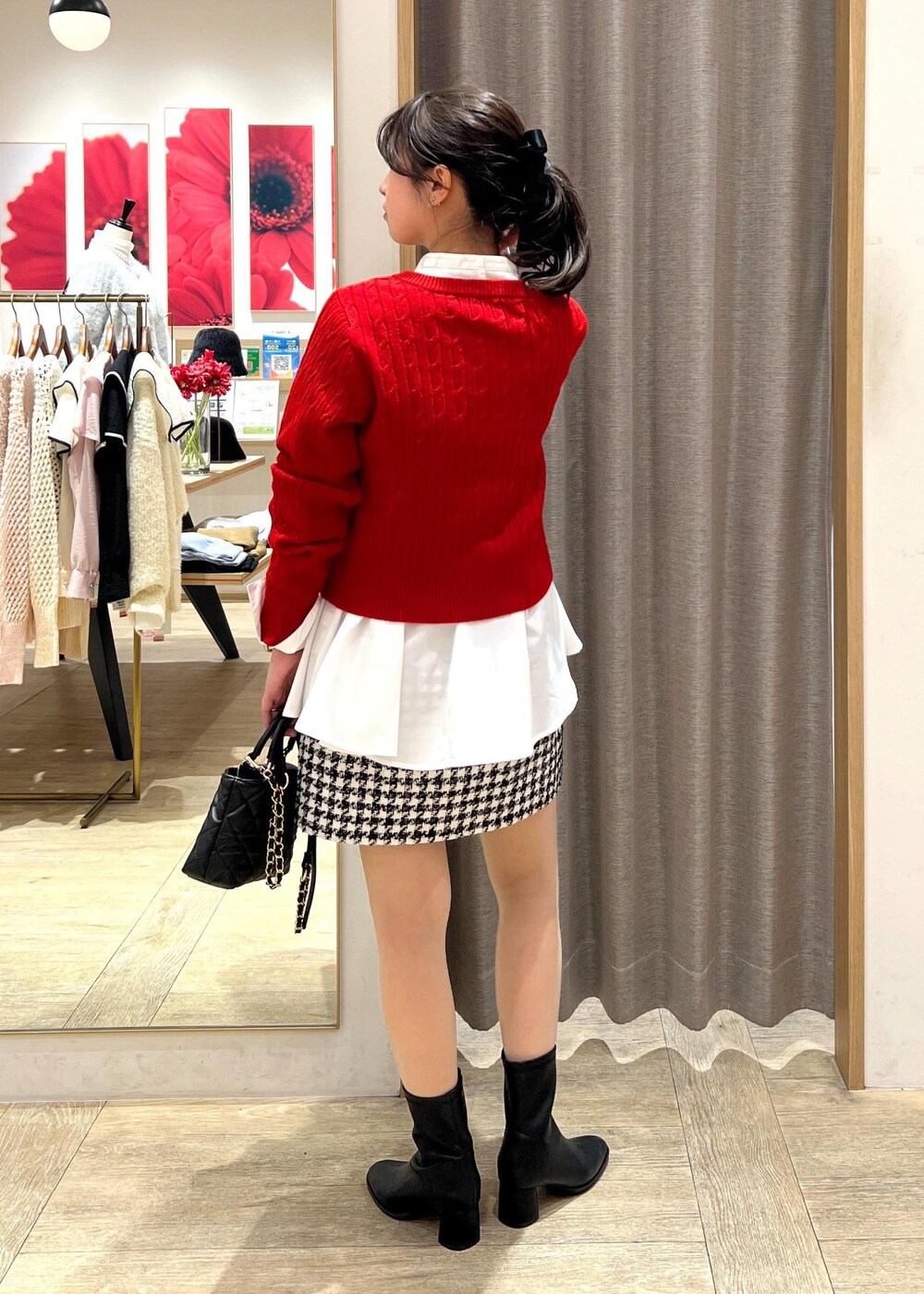 ブラック系のブーツ、ブラック系のスカート、ホワイト系のシャツ/ブラウスを着用したレディースの冬コーディネートの3枚目の写真