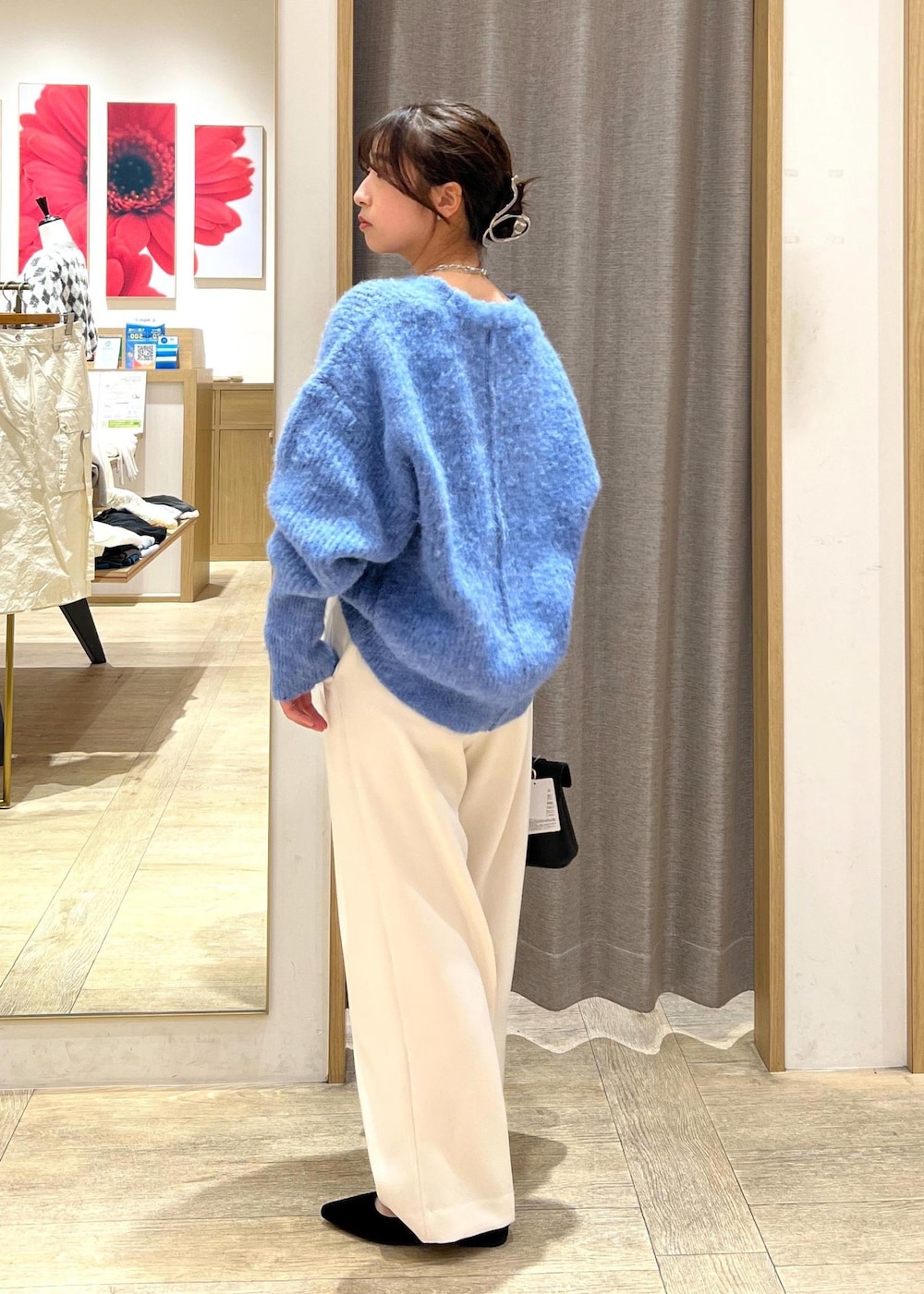 ブラック系のパンプス、ブラック系のショルダーバッグ、ブルー系のカーディガン/ボレロを着用したレディースの冬コーディネートの3枚目の写真