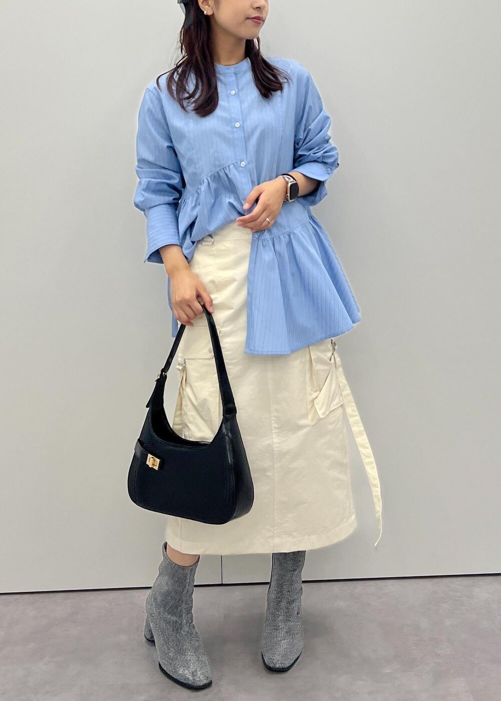 ホワイト系のスカート、シルバー系のブーツ、ブルー系のシャツ/ブラウスを着用したレディースの秋コーディネートの2枚目の写真