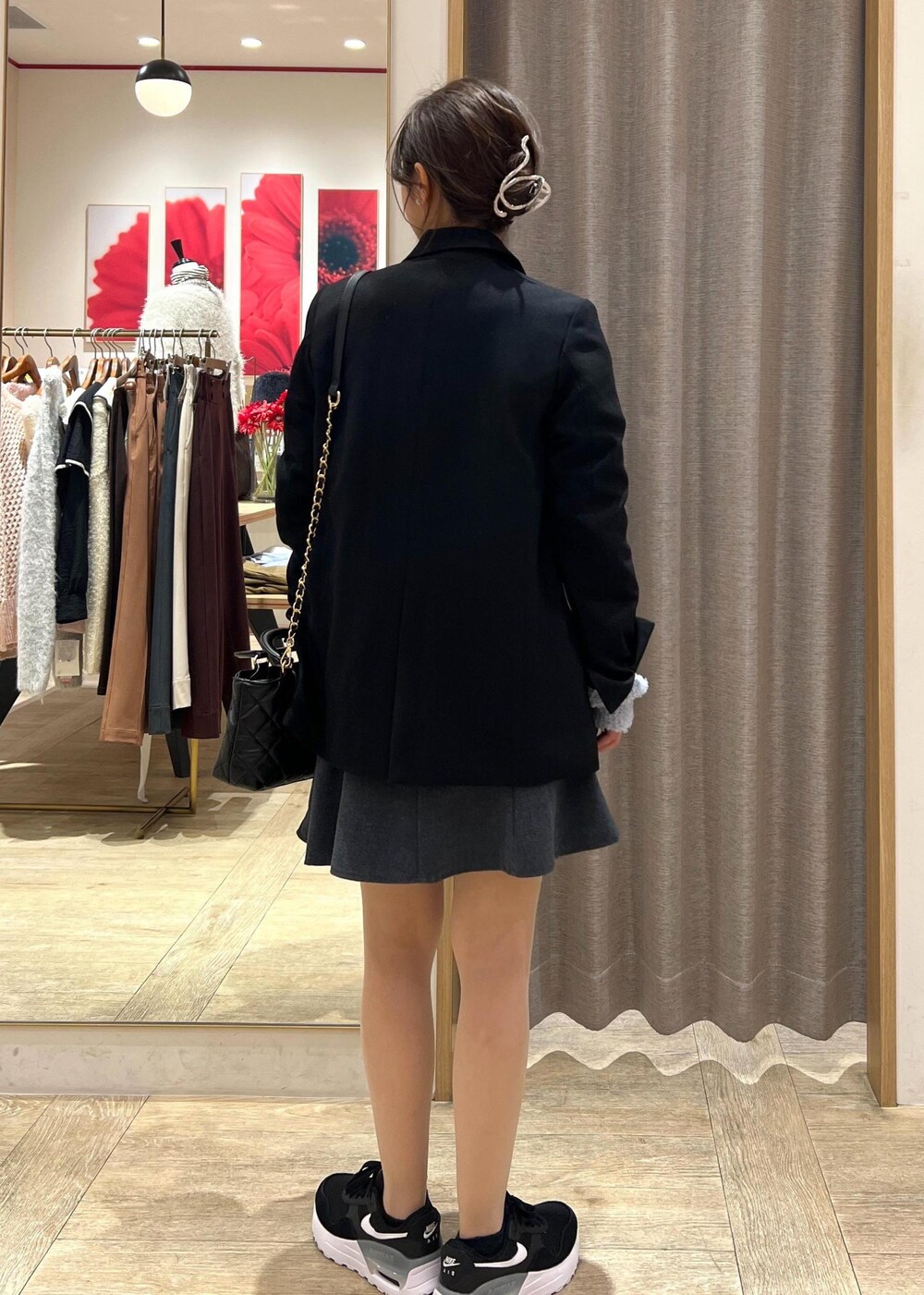 ブラック系のテーラードジャケット、ブラック系のスニーカー、ブルー系のカーディガン/ボレロを着用したレディースの冬コーディネートの4枚目の写真