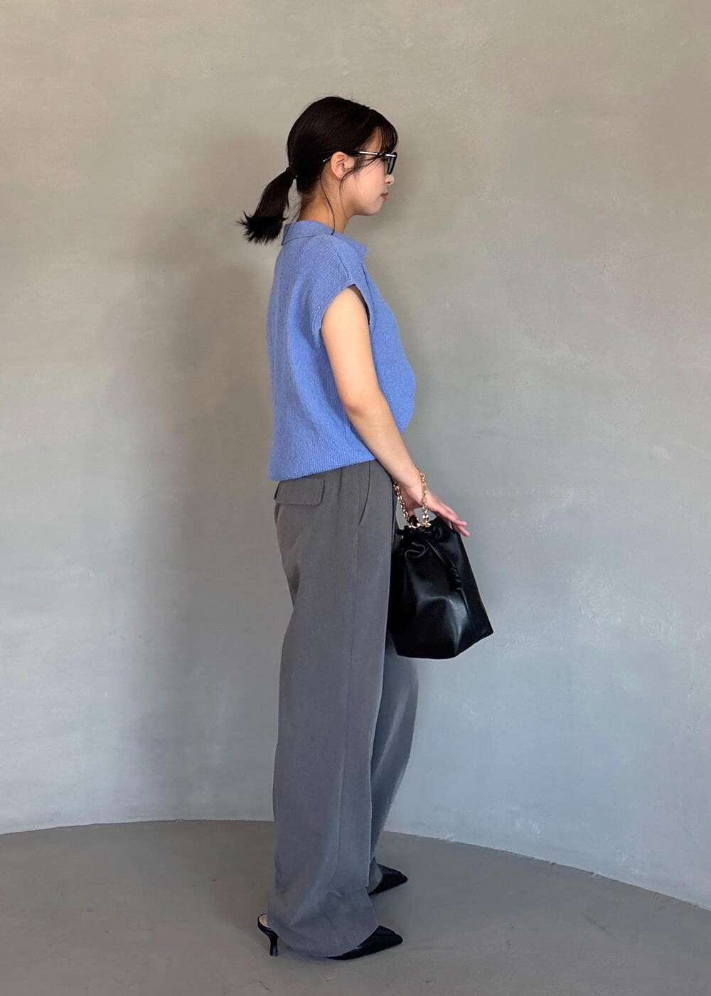 ブラック系のパンプス、ブルー系のスラックス、ブルー系のニット/セーターを着用したレディースの春コーディネートの4枚目の写真