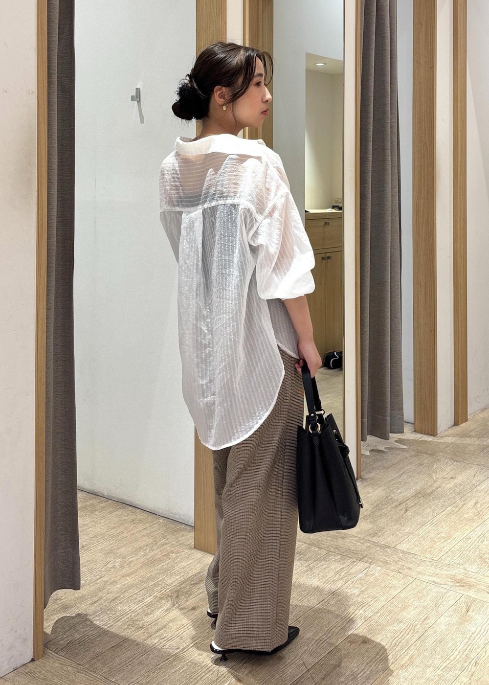 ブラック系のショルダーバッグ、ブラック系のパンプス、ホワイト系のシャツ/ブラウスを着用したレディースの秋コーディネートの2枚目の写真