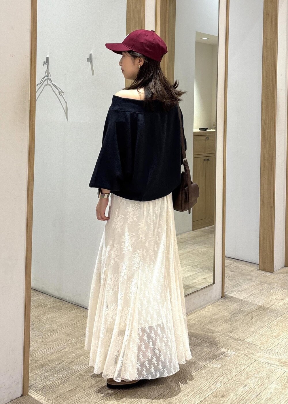 ブラウン系のショルダーバッグ、ベージュ系のローファー、ホワイト系のスカートを着用したレディースの秋コーディネートの3枚目の写真