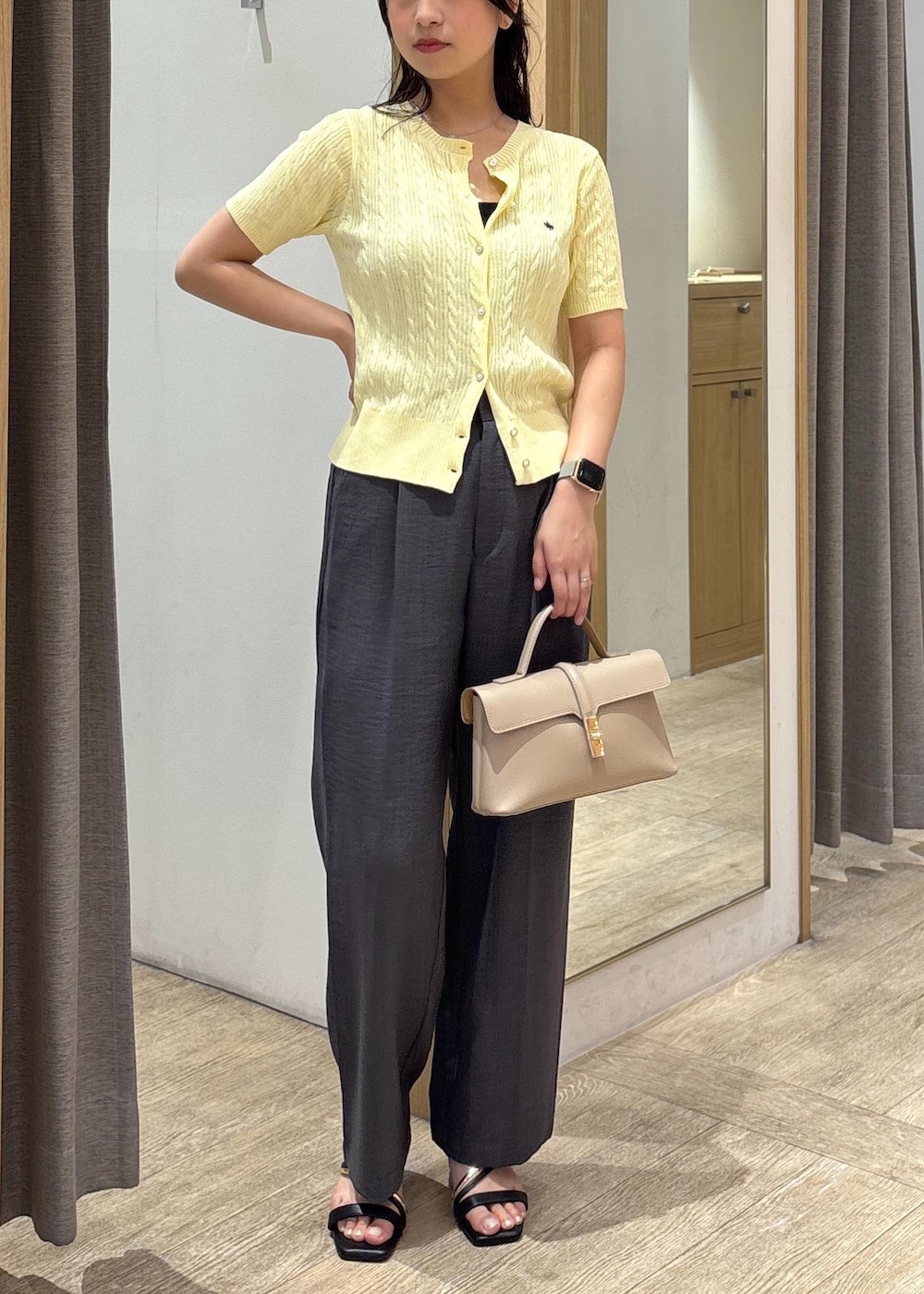 ベージュ系のショルダーバッグ、ブラック系のサンダル、グレー系のスラックスを着用したレディースの夏コーディネートの9枚目の写真