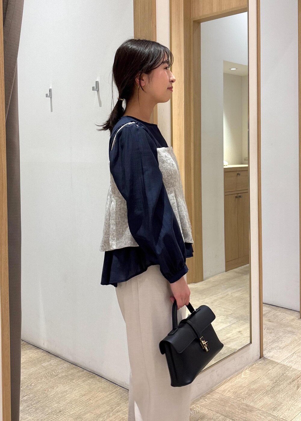 ブラック系のショルダーバッグ、ブルー系のシャツ/ブラウス、シルバー系のパンプスを着用したレディースの春コーディネートの7枚目の写真