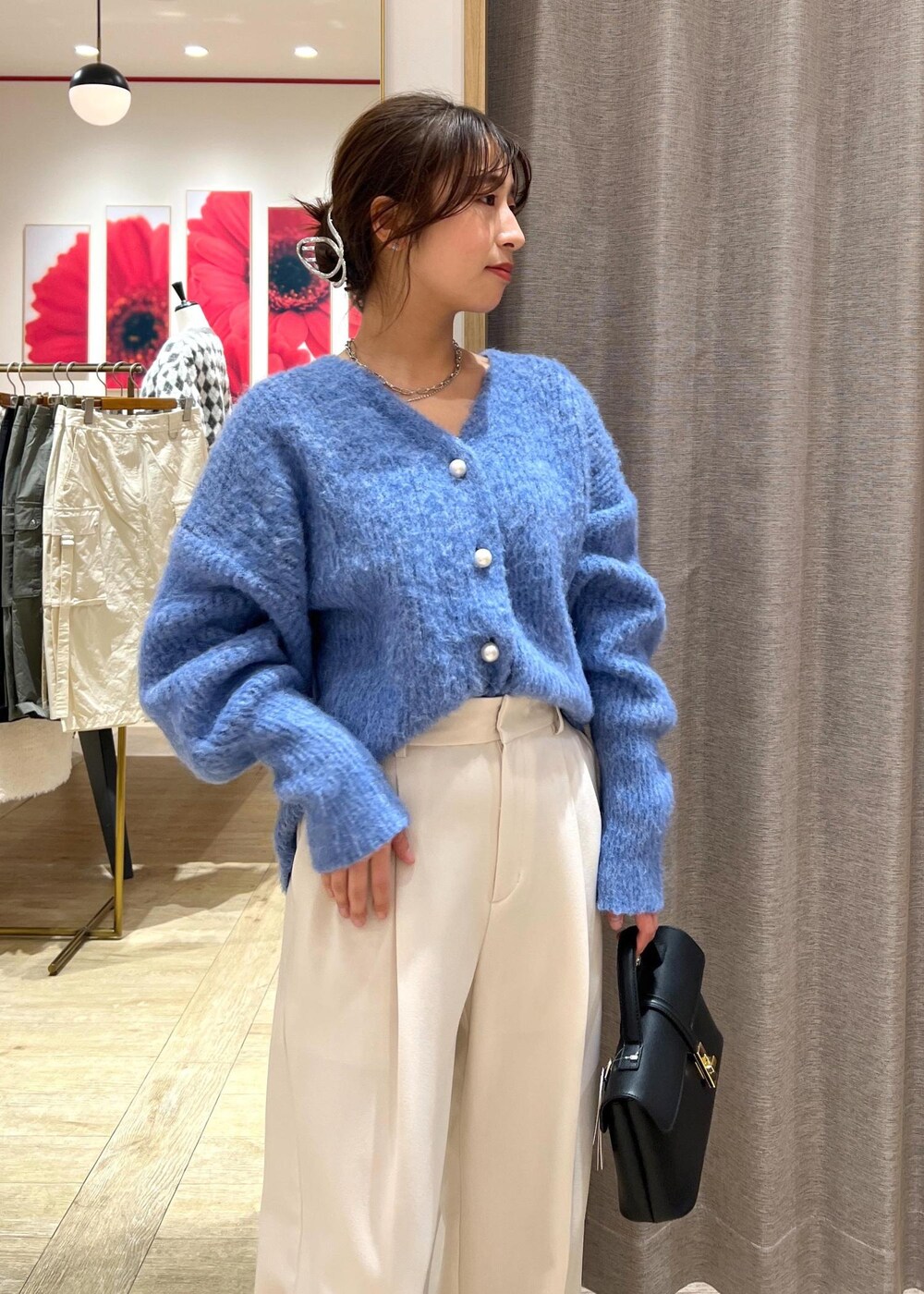 ブラック系のパンプス、ブラック系のショルダーバッグ、ブルー系のカーディガン/ボレロを着用したレディースの冬コーディネートの6枚目の写真