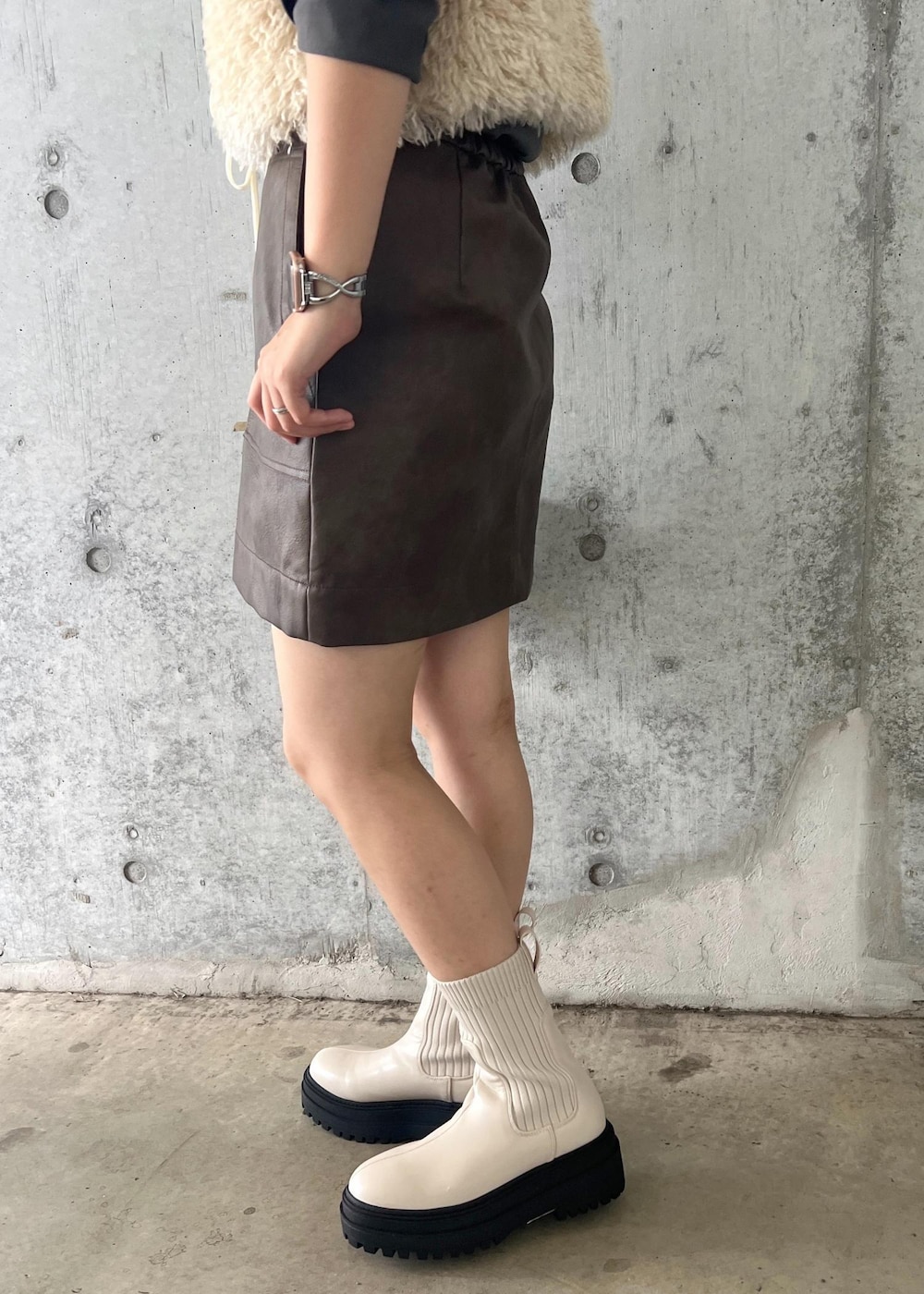 ホワイト系のブーツ、ブラウン系のスカート、ホワイト系のキャミソールを着用したレディースの秋コーディネートの9枚目の写真