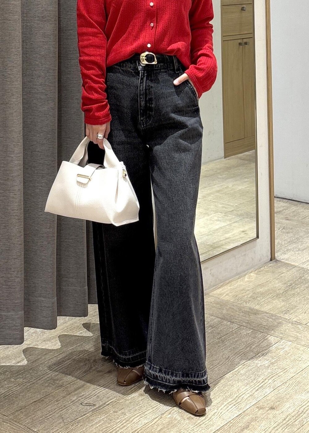 ブラウン系のパンプス、レッド系のカーディガン/ボレロ、ブラック系のデニムパンツを着用したレディースの春コーディネートの10枚目の写真