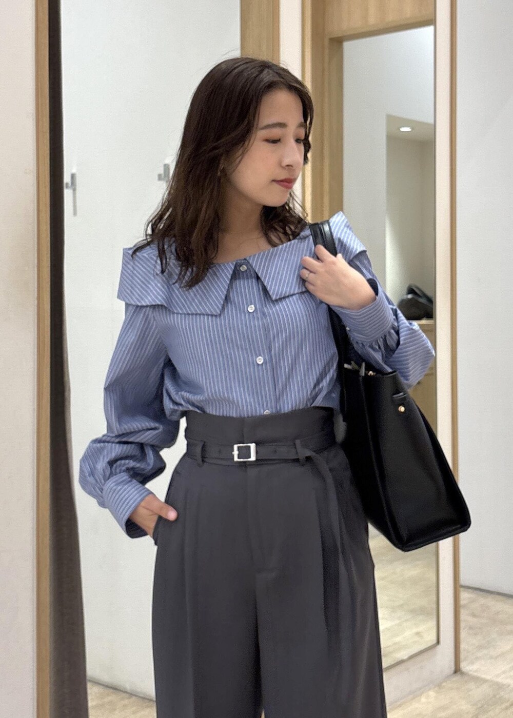 ブラック系のトートバッグ、ブラック系のパンプス、ブルー系のシャツ/ブラウスを着用したレディースの秋コーディネートの5枚目の写真