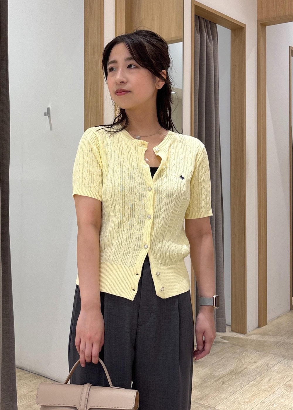 ベージュ系のショルダーバッグ、ブラック系のサンダル、グレー系のスラックスを着用したレディースの夏コーディネートの7枚目の写真