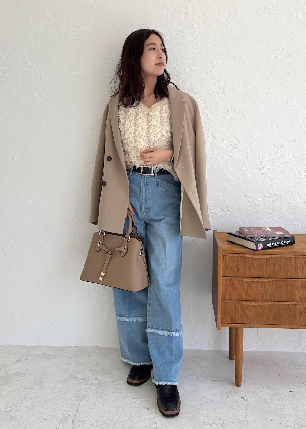 ブラック系のローファー、ホワイト系のベスト、ブルー系のデニムパンツを着用したレディースの夏コーディネートの2枚目の写真