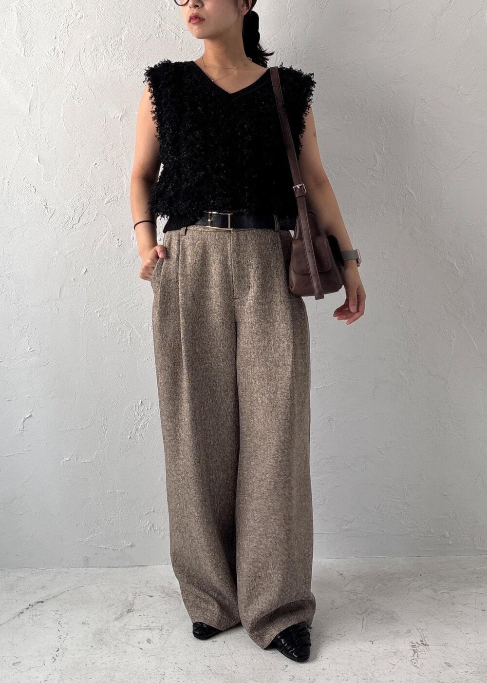 ブラック系のパンプス、ブラック系のベスト、ブラウン系のショルダーバッグを着用したレディースの夏コーディネートの9枚目の写真