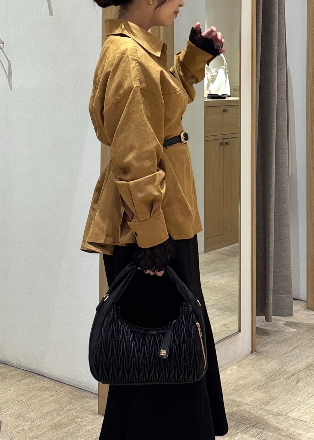 ブラック系のスカート、ブラック系のTシャツ/カットソー、ブラック系のハンドバッグを着用したレディースの秋コーディネートの8枚目の写真