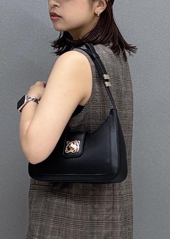 ブラック系のショルダーバッグ、ブラック系のパンプス、ブラウン系のベストを着用したレディースの夏コーディネートの8枚目の写真