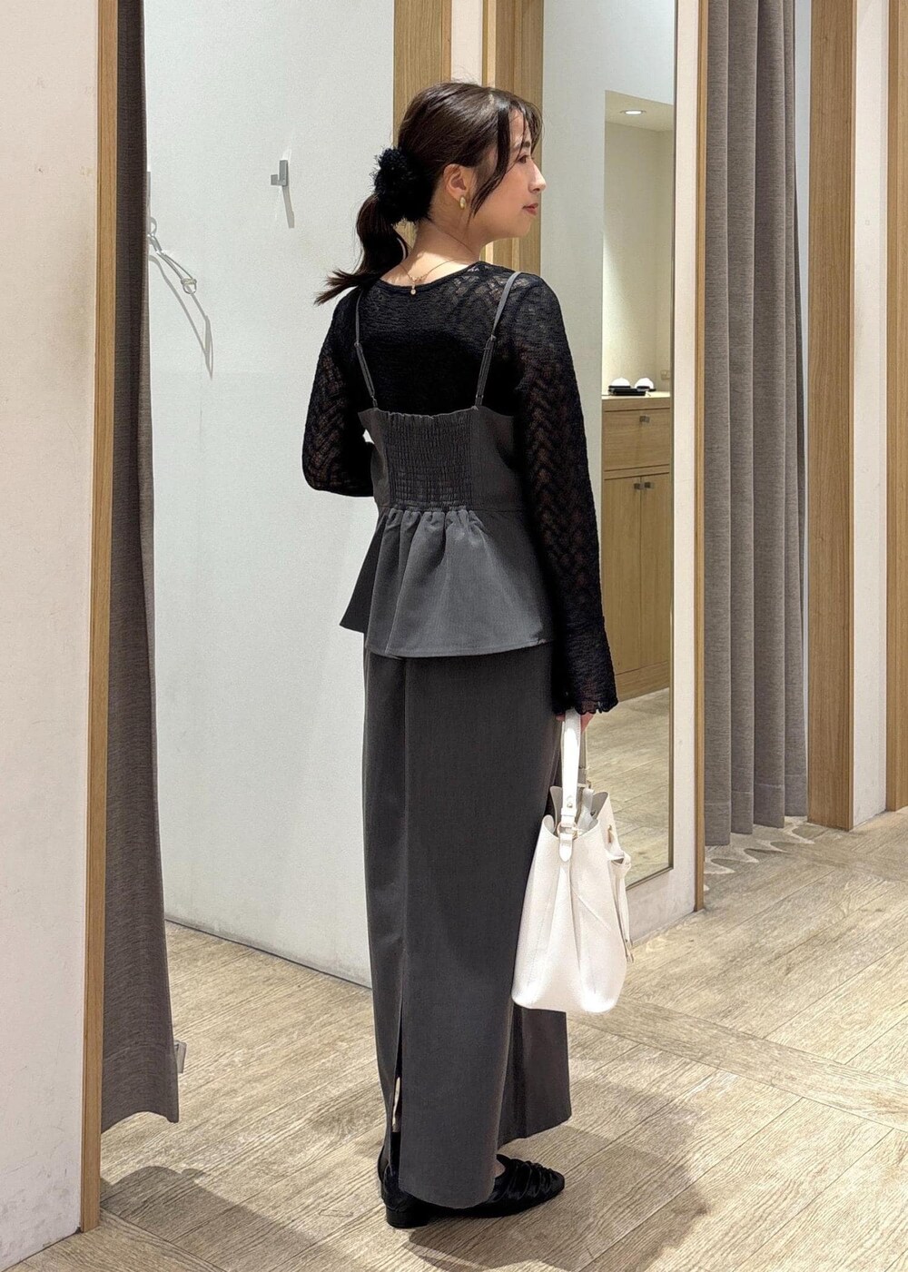 ホワイト系のショルダーバッグ、ブラック系のパンプス、グレー系のワンピースを着用したレディースの秋コーディネートの3枚目の写真