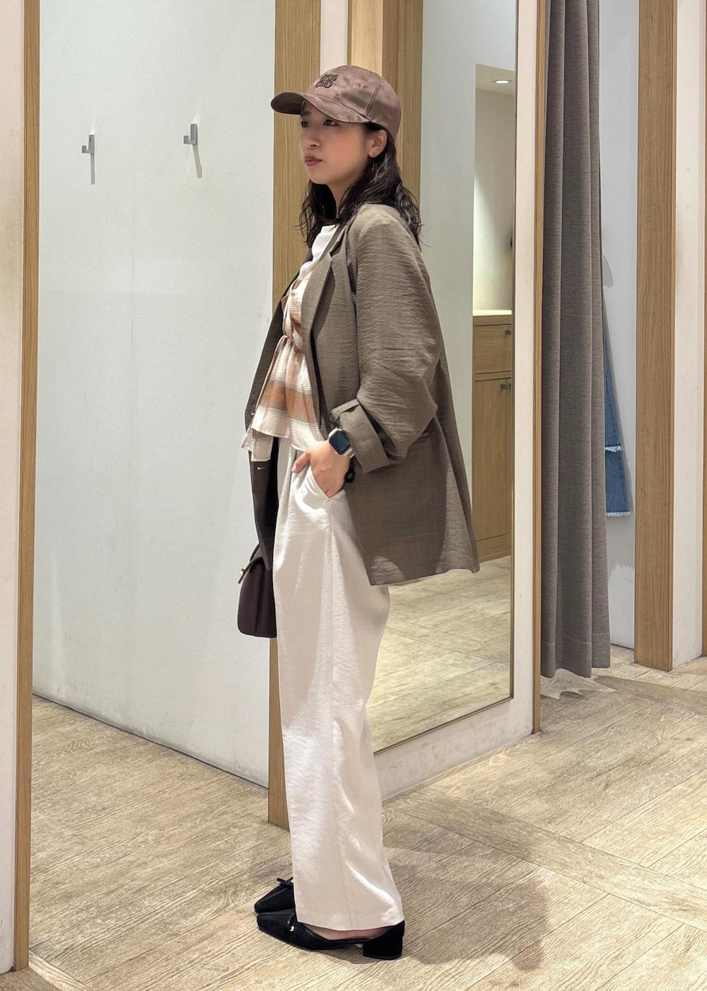 ブラウン系のショルダーバッグ、グリーン系のテーラードジャケット、ホワイト系のスラックスを着用したレディースの夏コーディネートの2枚目の写真