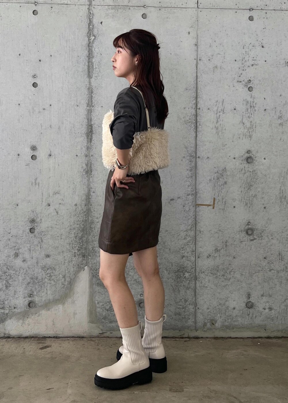ホワイト系のブーツ、ブラウン系のスカート、ホワイト系のキャミソールを着用したレディースの秋コーディネートの3枚目の写真