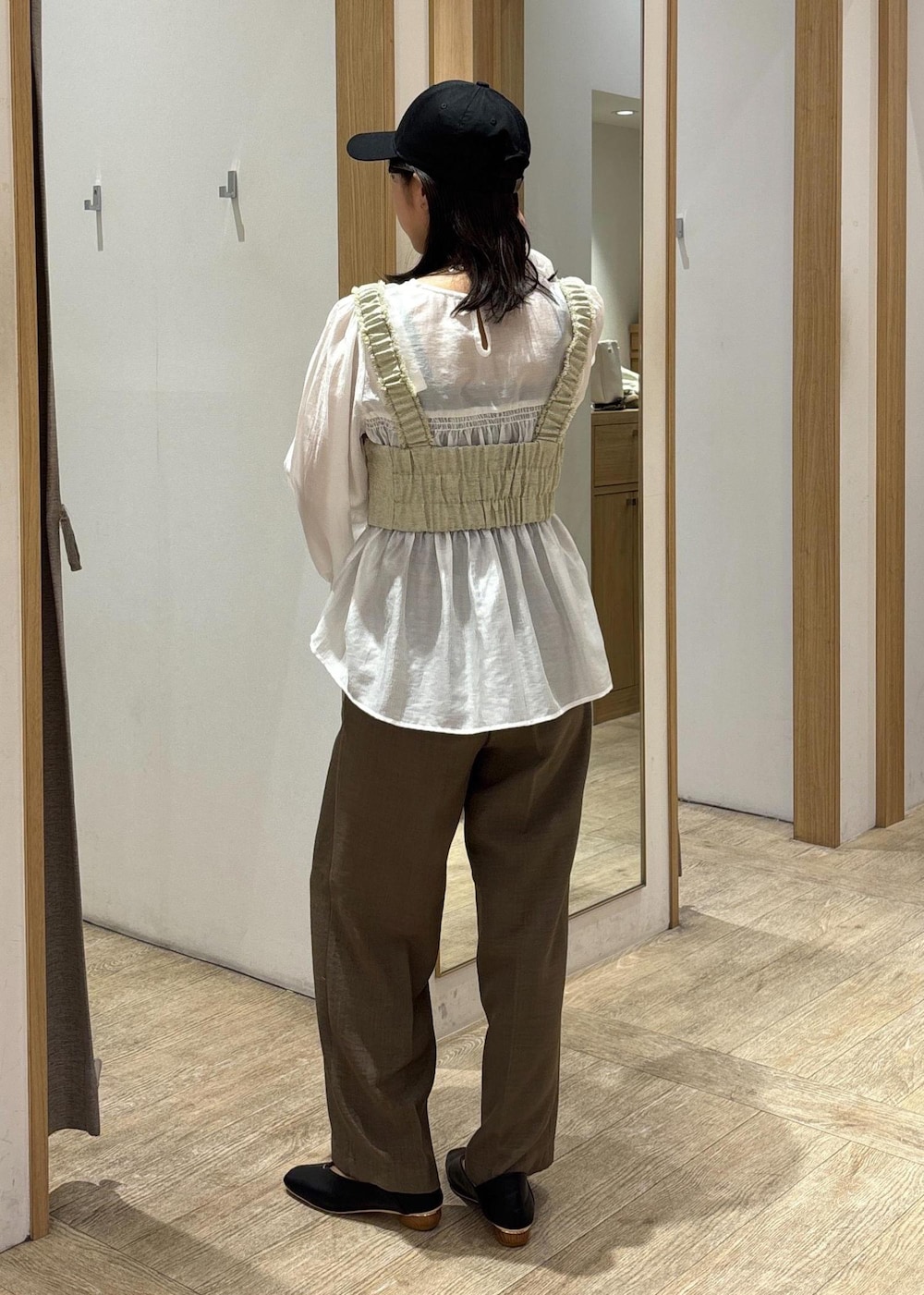 ホワイト系のシャツ/ブラウス、ブラック系のパンプス、ホワイト系のベストを着用したレディースの春コーディネートの3枚目の写真