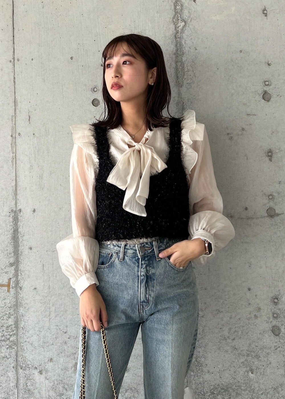 ブルー系のデニムパンツ、ブラック系のキャミソール、シルバー系のブーツを着用したレディースの秋コーディネートの6枚目の写真