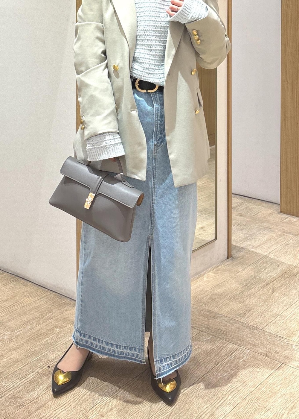 グレー系のショルダーバッグ、ブラック系のバレエシューズ、ブルー系のデニムスカートを着用したレディースの冬コーディネートの8枚目の写真