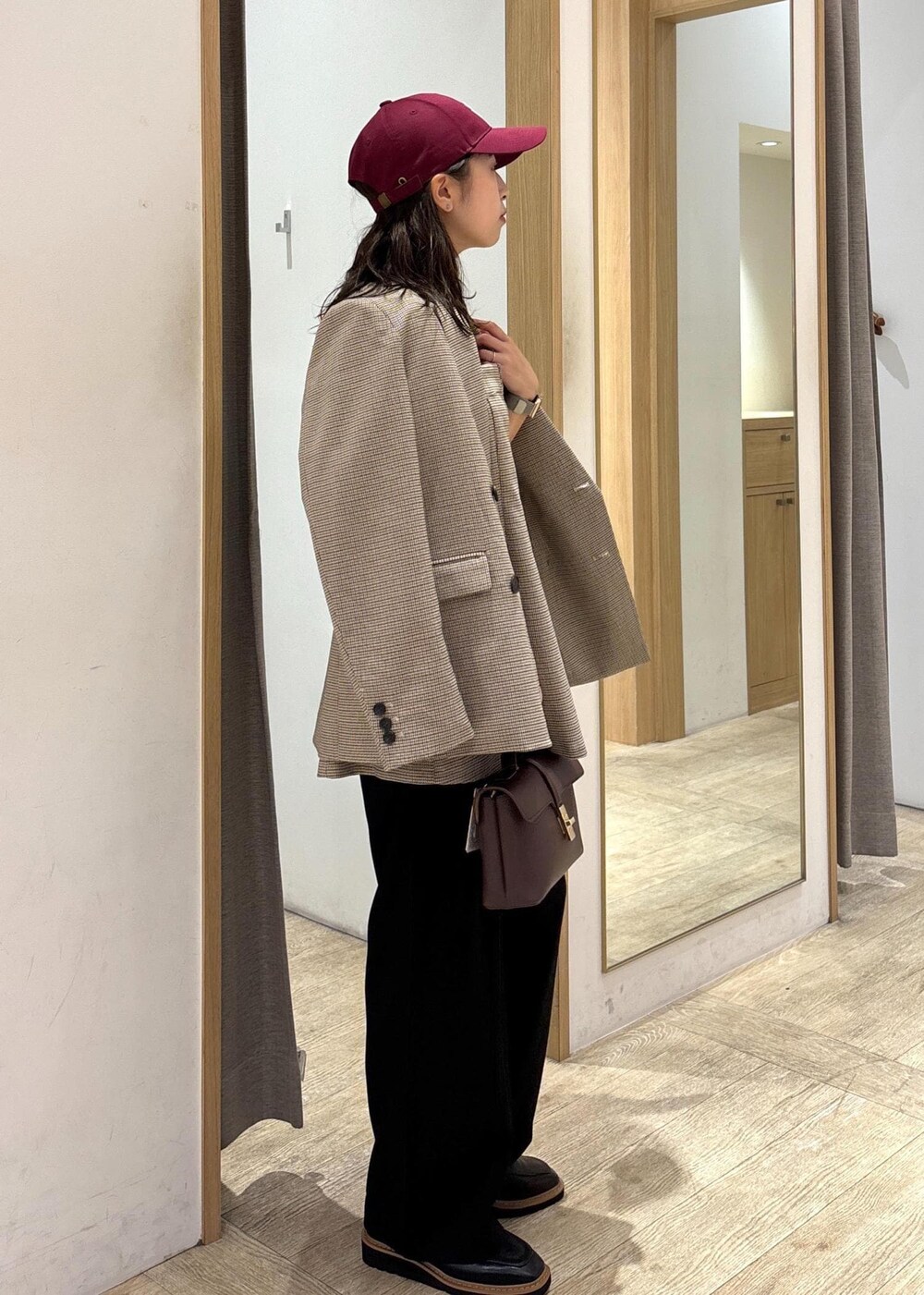 ブラウン系のショルダーバッグ、ベージュ系のテーラードジャケット、ベージュ系のキャミソールを着用したレディースの秋コーディネートの4枚目の写真