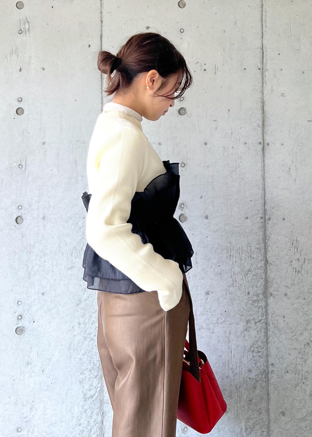 レッド系のショルダーバッグ、ブラック系のパンプス、ホワイト系のニット/セーターを着用したレディースの冬コーディネートの9枚目の写真