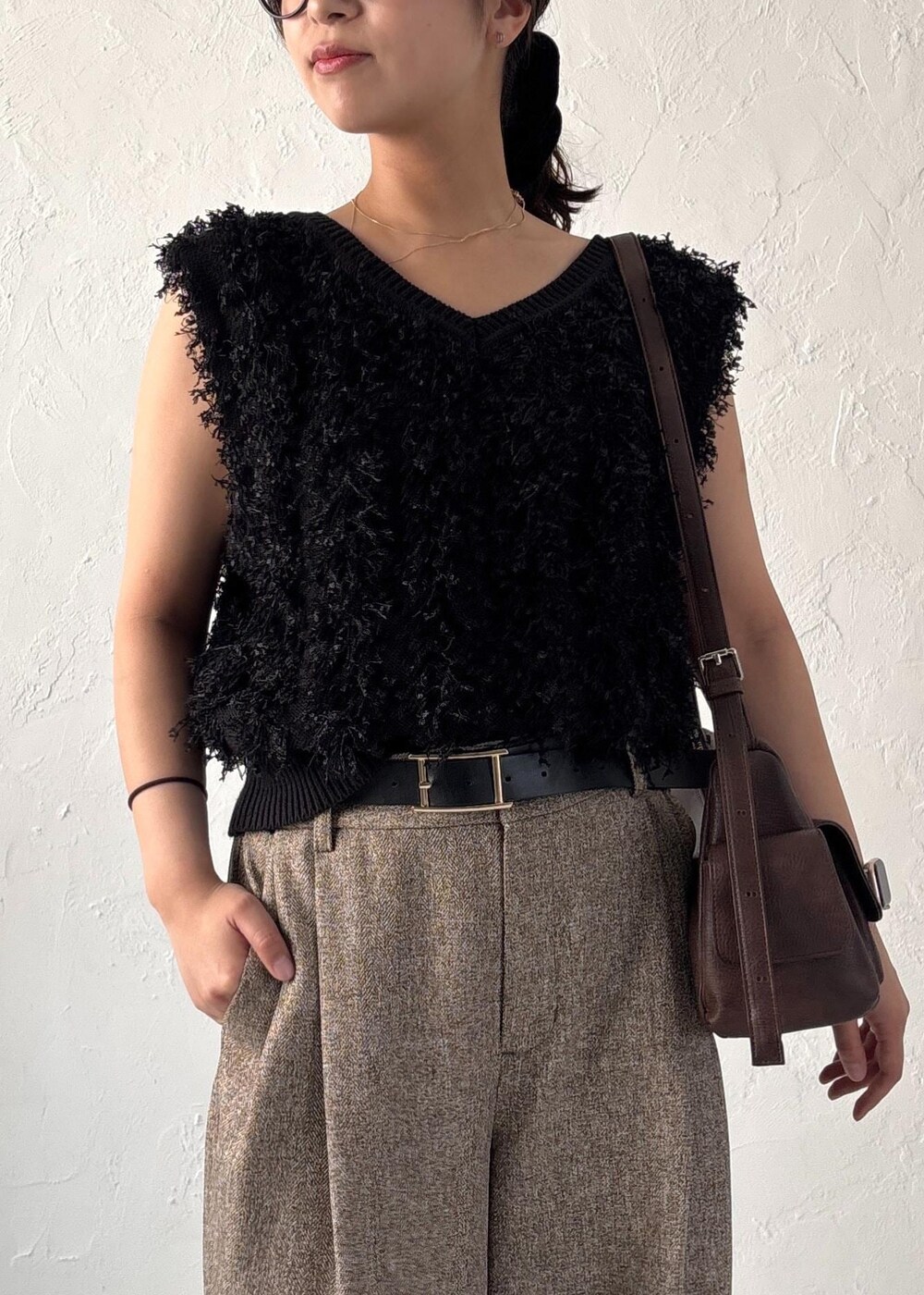 ブラック系のパンプス、ブラック系のベスト、ブラウン系のショルダーバッグを着用したレディースの夏コーディネートの5枚目の写真