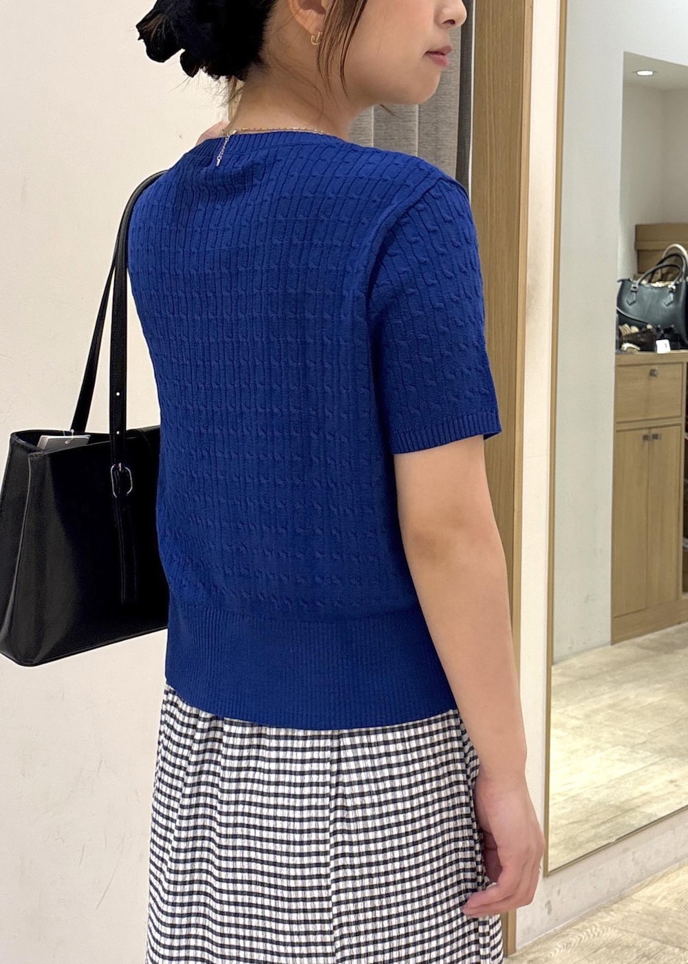 ブラック系のトートバッグ、シルバー系のサンダル、ブルー系のカーディガン/ボレロを着用したレディースの春コーディネートの8枚目の写真