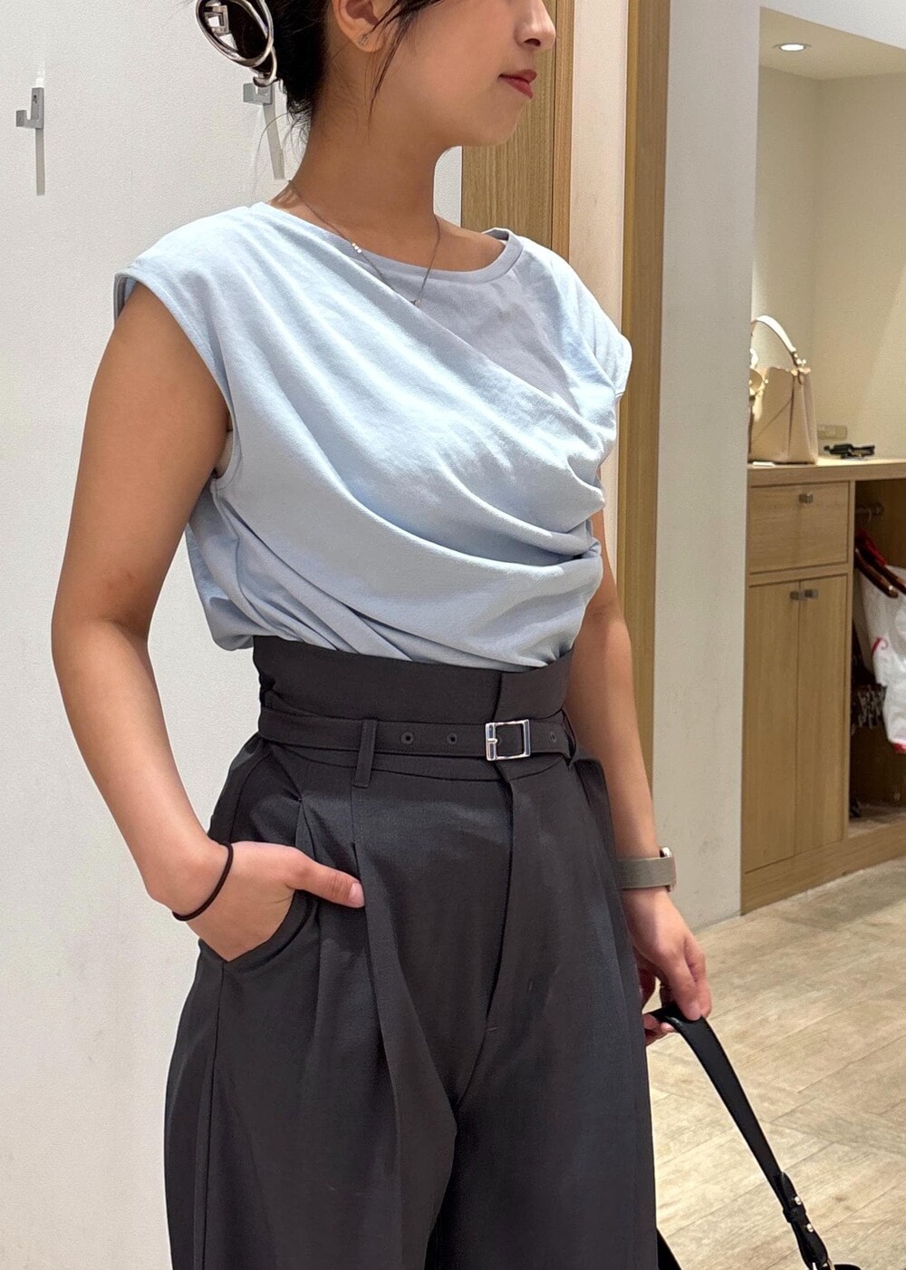 ブラック系のサンダル、ブルー系のTシャツ/カットソー、グレー系のスラックスを着用したレディースの夏コーディネートの5枚目の写真