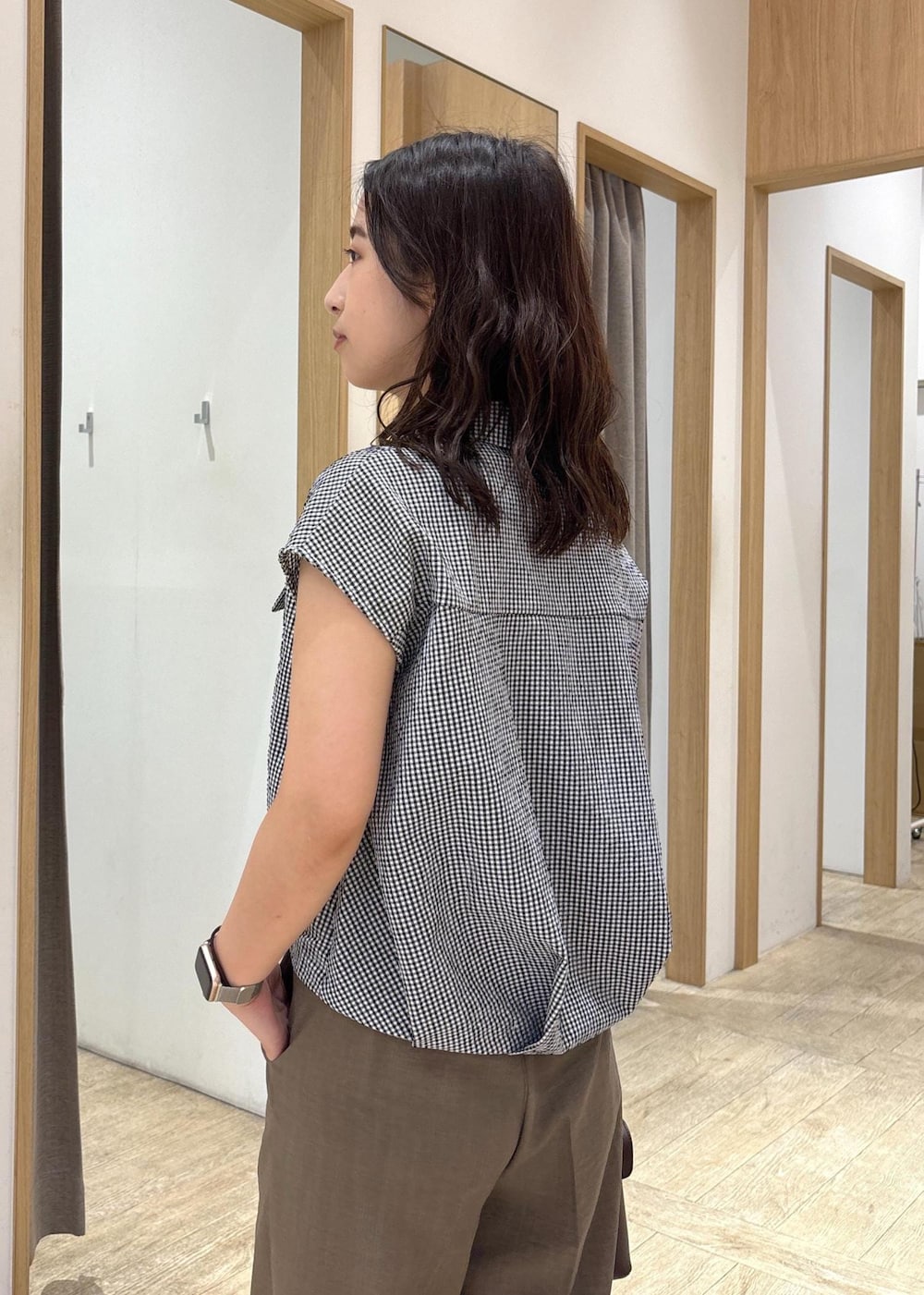 ブラウン系のショルダーバッグ、グリーン系のスラックス、ブラック系のシャツ/ブラウスを着用したレディースの夏コーディネートの6枚目の写真