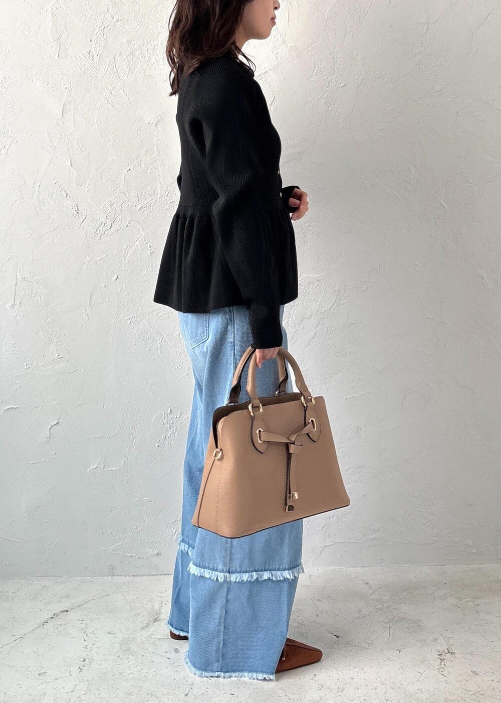 ブルー系のデニムパンツ、イエロー系のパンプス、ベージュ系のボストンバッグを着用したレディースの夏コーディネートの4枚目の写真