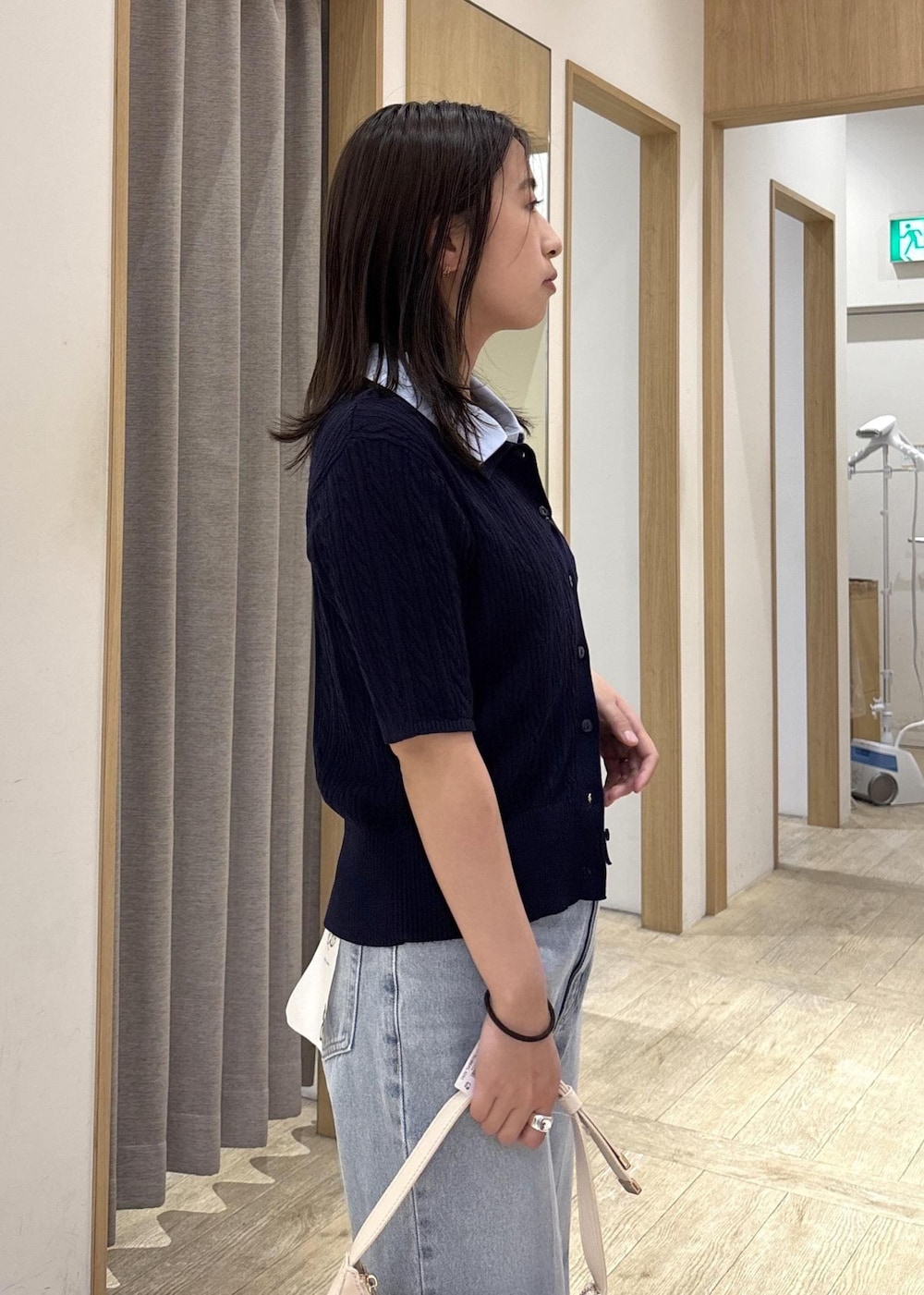 ホワイト系のショルダーバッグ、ホワイト系のパンプス、ブルー系のカーディガン/ボレロを着用したレディースの春コーディネートの8枚目の写真