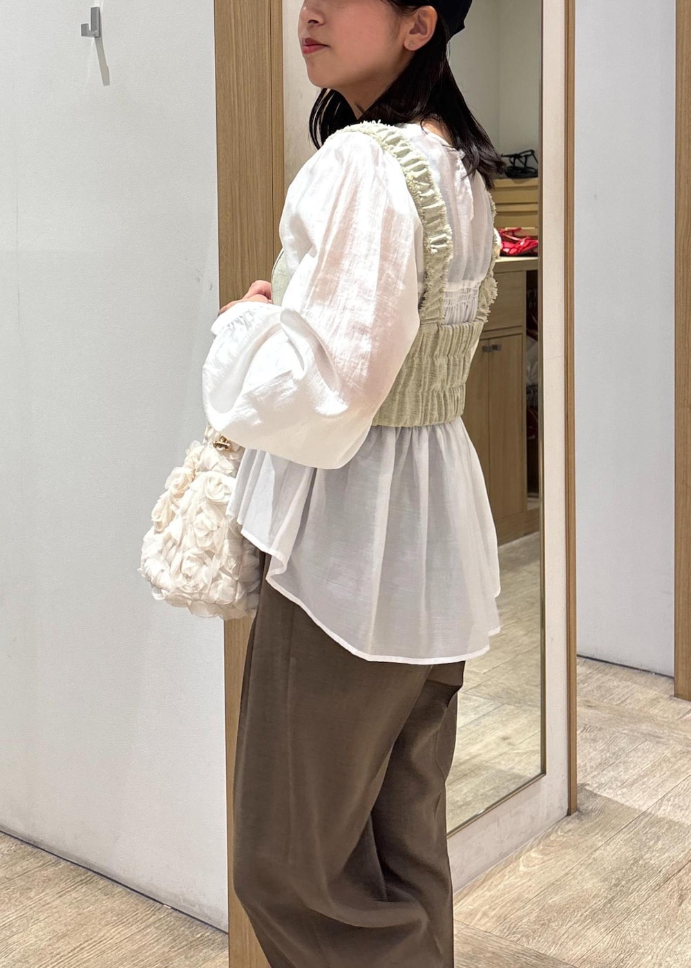 ホワイト系のシャツ/ブラウス、ブラック系のパンプス、ホワイト系のベストを着用したレディースの春コーディネートの9枚目の写真