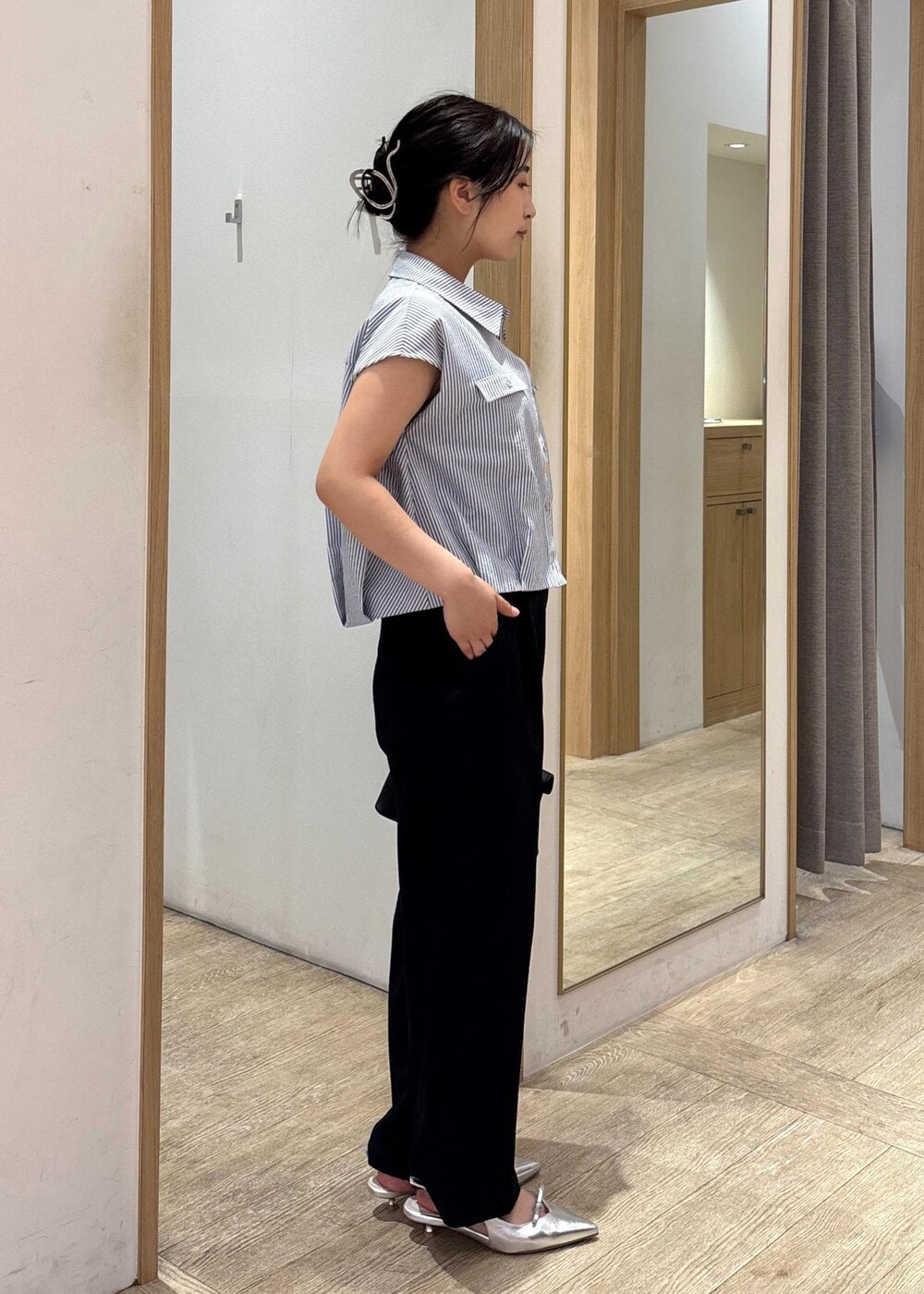 ブラック系のショルダーバッグ、シルバー系のパンプス、ブラック系のシャツ/ブラウスを着用したレディースの夏コーディネートの2枚目の写真