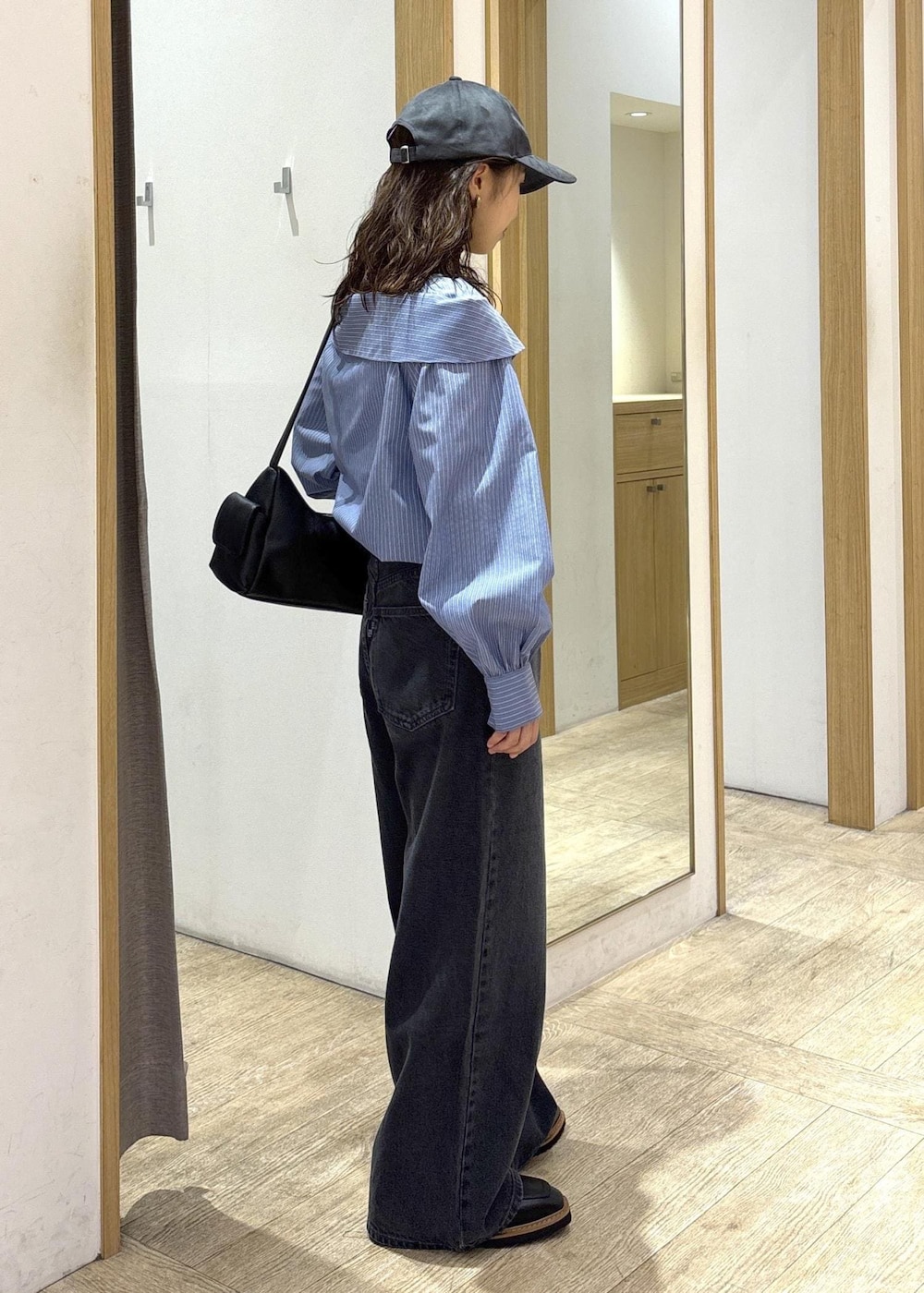 ブラック系のショルダーバッグ、ブラック系のローファー、ブルー系のシャツ/ブラウスを着用したレディースの秋コーディネートの4枚目の写真