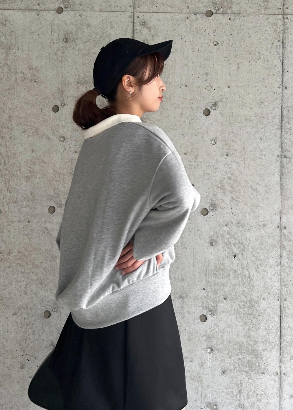 ブラック系のブーツ、ブラック系のハンドバッグ、ブラック系のスカートを着用したレディースの秋コーディネートの6枚目の写真