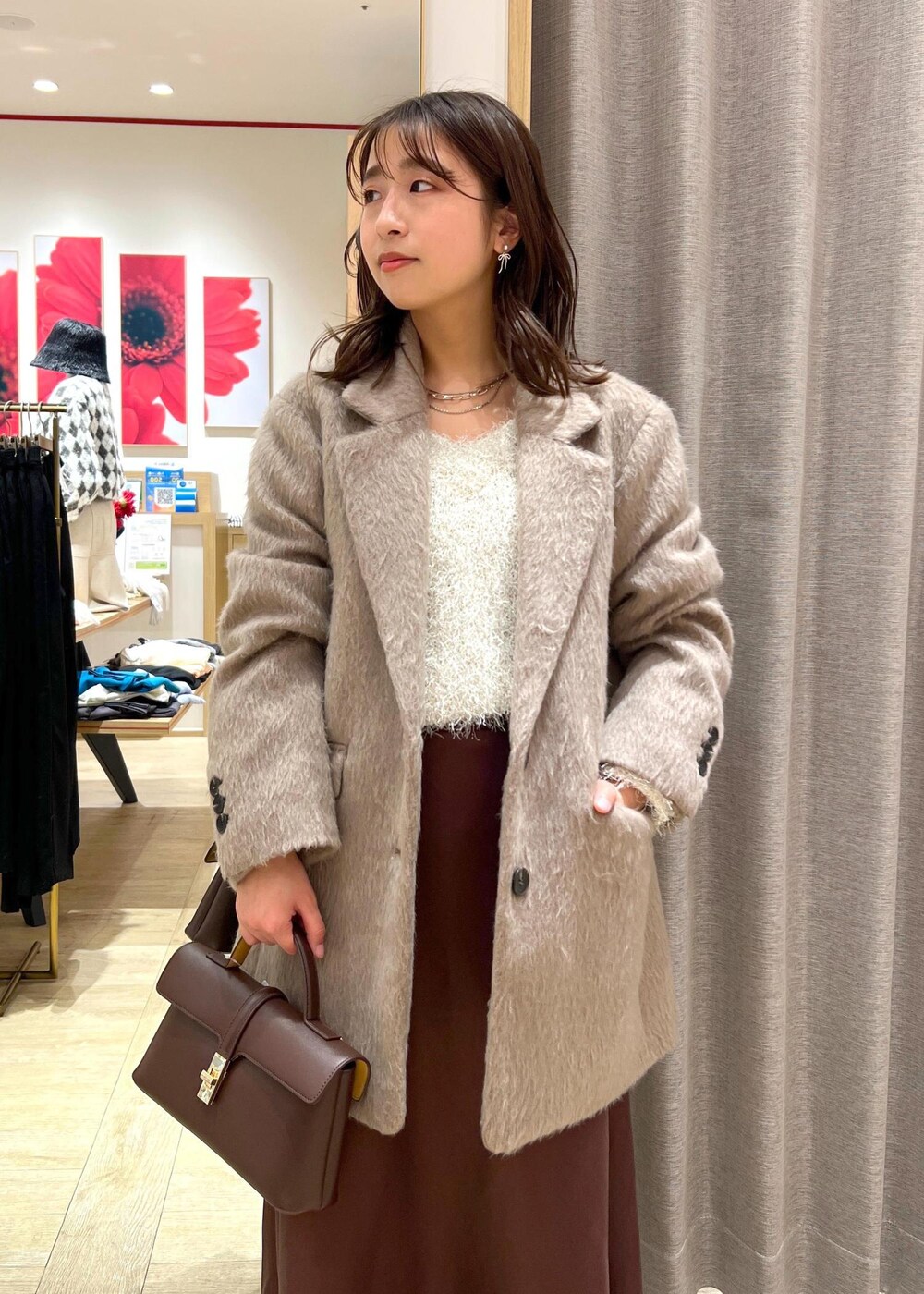 ブラック系のパンプス、ブラウン系のスカート、ホワイト系のニット/セーターを着用したレディースの冬コーディネートの7枚目の写真