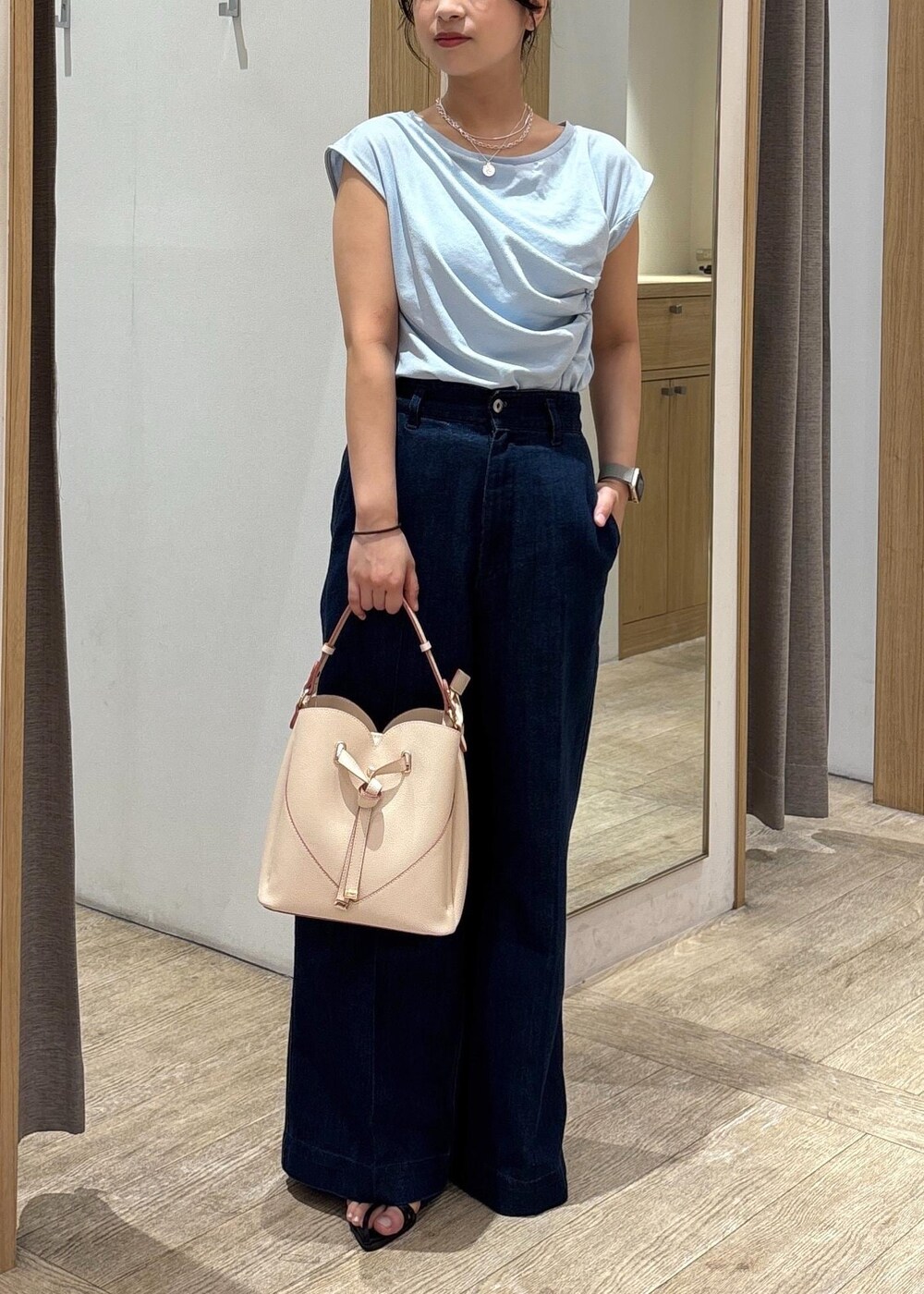 ベージュ系のショルダーバッグ、ブラック系のサンダル、ブルー系のTシャツ/カットソーを着用したレディースの夏コーディネートの2枚目の写真